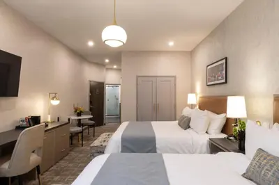 a hotel room with two beds and a desk at Broadway Plaza Hotel in New York