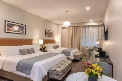 a hotel room with two beds and a couch at Broadway Plaza Hotel in New York