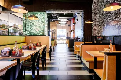 a restaurant with tables and chairs and a green wall at Kixby in New York