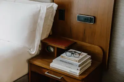 a nightstand with books and a clock and a bed at Hotel Boutique at Grand Central in New York