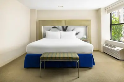 a bedroom with a large white bed and a stool at The Shoreham in New York