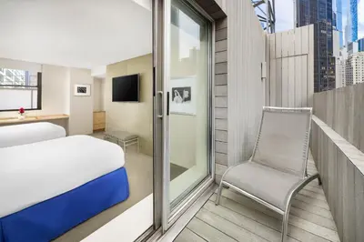 a bedroom with a bed and a chair and a window at The Shoreham in New York