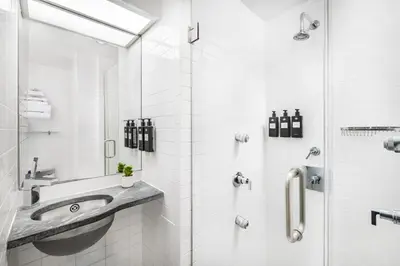 a white bathroom with a sink and a shower at The Shoreham in New York
