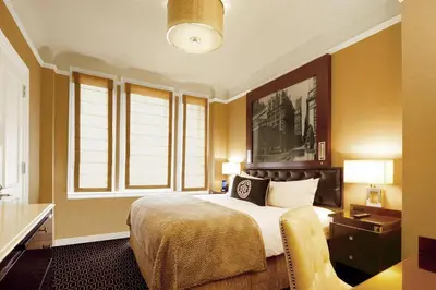 a bedroom with a large bed and two windows at The Algonquin Hotel Times Square, Autograph Collection in New York