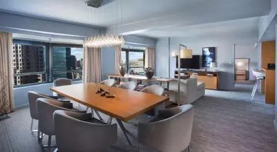 a dining room and living room with a table and chairs at New York Hilton Midtown in New York