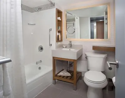 a bathroom with a toilet and a sink and a mirror at New York Hilton Midtown in New York