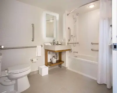 a bathroom with a toilet and a sink and a tub at New York Hilton Midtown in New York