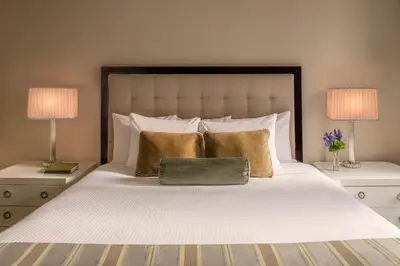 a bed with a green bag on it with two lamps at Warwick New York in New York