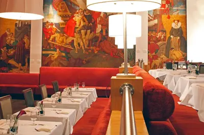 a dining room with white tables and a painting on the wall at Warwick New York in New York