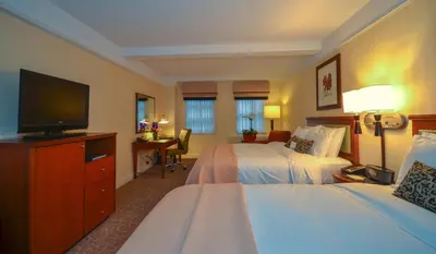 a hotel room with two beds and a flat screen tv at San Carlos Hotel New York in New York