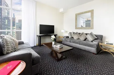 a living room with a couch and a tv at Millennium Hotel Broadway Times Square in New York