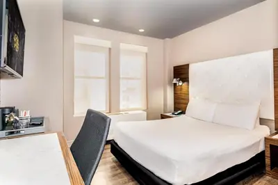 a hotel room with a bed and a desk at The Gallivant Times Square in New York