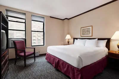 a hotel room with a large bed and a tv at Night Hotel Broadway in New York