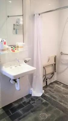 a white bathroom with a sink and a shower at Night Hotel Broadway in New York