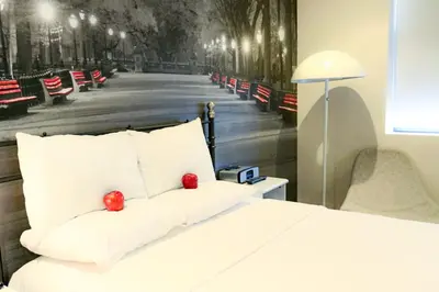 a bedroom with a bed with red apples on it at Night Hotel Broadway in New York