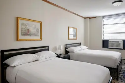 two beds in a room with white walls at Night Hotel Broadway in New York