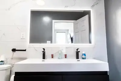 a white bathroom with a sink and a mirror at Shefah Hotel in Union City