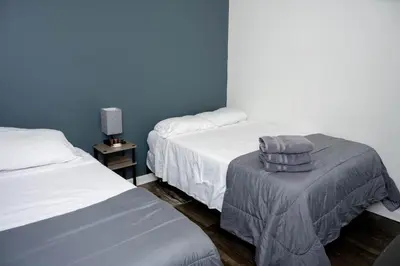 a room with two beds and a table with towels at Shefah Hotel in Union City