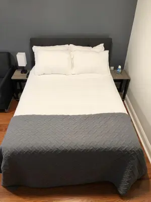 a large bed in a room with two side tables at Shefah Hotel in Union City