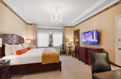 a large hotel room with a bed and a desk at The Sherry Netherland in New York