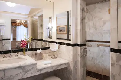 a bathroom with a sink and a shower with a mirror at The Sherry Netherland in New York
