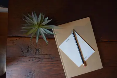 a notebook and a pencil on a table with a plant at Sohotel in New York