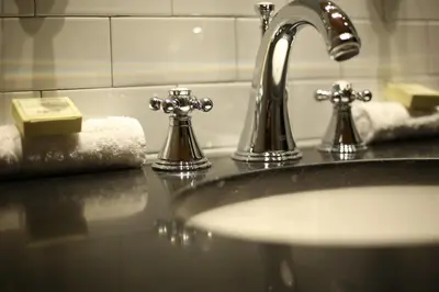 a bathroom sink with two faucets and towels at Sohotel in New York