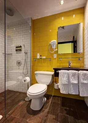 a bathroom with a toilet and a shower with towels at Sohotel in New York