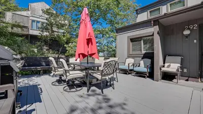 a patio with a table with chairs and an umbrella at Cozy Modern Camelback House in Tannersville
