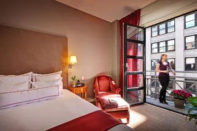a woman standing on a balcony in a hotel room at Hotel Giraffe by Library Hotel Collection in New York