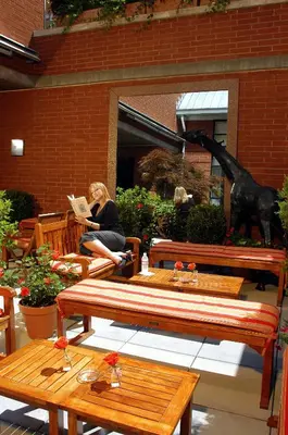 a woman sitting on a bench reading a book at Hotel Giraffe by Library Hotel Collection in New York
