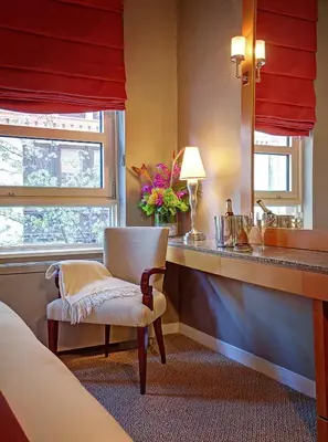 a bedroom with a desk with a chair and a mirror at Hotel Giraffe by Library Hotel Collection in New York