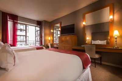 a hotel room with two beds and a mirror at Hotel Giraffe by Library Hotel Collection in New York
