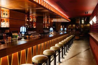 a bar with a row of stools at The Renwick in New York