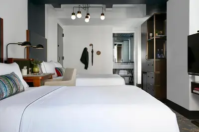 a bedroom with two white beds and a desk at The Renwick in New York