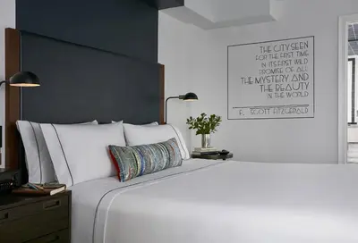 a bedroom with a large white bed with a black wall at The Renwick in New York