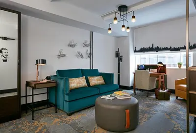 a living room with a blue couch and a table at The Renwick in New York