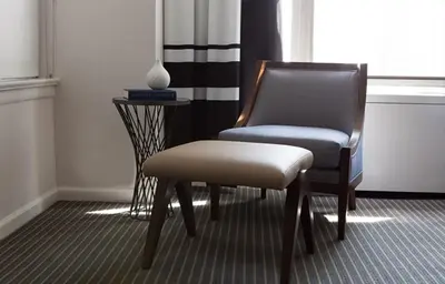 a chair sitting next to a window in a room at The Fifty Sonesta Hotel New York in New York