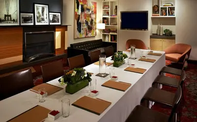 a meeting room with a long table with flowers on it at The Fifty Sonesta Hotel New York in New York