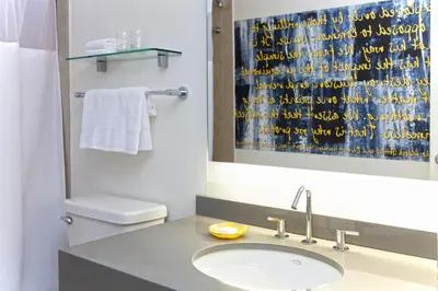 a bathroom with a sink and a toilet and a mirror at The Fifty Sonesta Hotel New York in New York