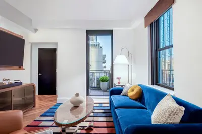 a living room with a blue couch and a table at The Benjamin Royal Sonesta New York in New York