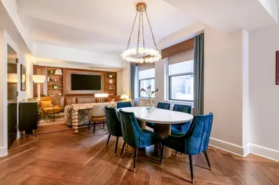 a dining room and living room with a table and chairs at The Benjamin Royal Sonesta New York in New York