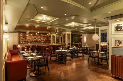 a restaurant with tables and chairs and a bar at The Benjamin Royal Sonesta New York in New York