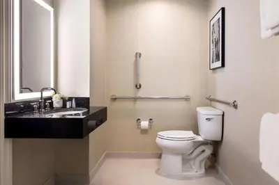 a bathroom with a toilet and a sink at The Shelburne Sonesta New York in New York