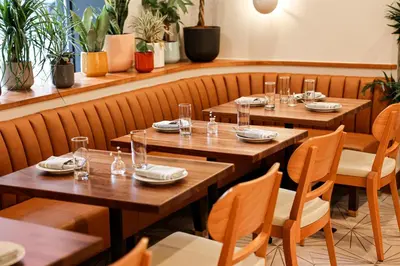 a row of wooden tables in a restaurant at The Shelburne Sonesta New York in New York