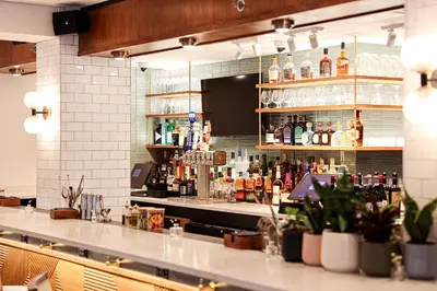 a bar with a lot of bottles of alcohol at The Shelburne Sonesta New York in New York