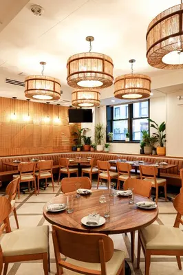 a restaurant with tables and chairs and chandeliers at The Shelburne Sonesta New York in New York