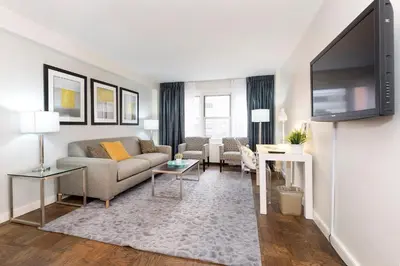 a living room with a couch and a flat screen tv at Murray Hill East Suites - Extended Stay in New York