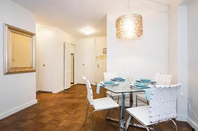 a dining room with a table and white chairs at Murray Hill East Suites - Extended Stay in New York