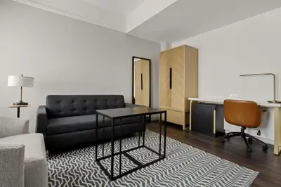 a living room with a couch and a table and a desk at Newly Renovated Rooms at Club Quarters Hotel Times Square, New York in New York